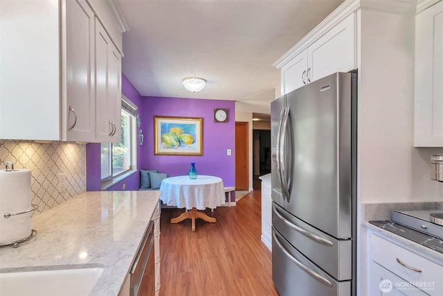 1515 NE 106th St, Seattle, WA 98125 - kitchen featuring stainless steel appliances, white cabinets, light wood-style floors, tasteful backsplash, and light stone countertops