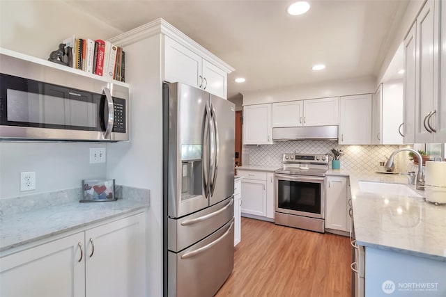 1515 NE 106th St, Seattle, WA 98125 - kitchen featuring appliances with stainless steel finishes, white cabinetry, light wood-style floors, backsplash, and recessed lighting