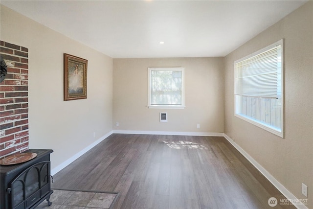837 NW Duffy St, Chehalis, WA 98532 - empty room with dark wood finished floors and a wood stove