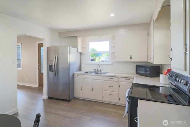 837 NW Duffy St, Chehalis, WA 98532 - kitchen featuring electric range, stainless steel fridge, black microwave, white cabinetry, and light wood finished floors