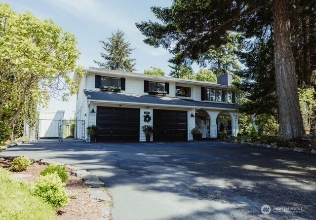 1327 Marie View St, Port Angeles, WA 98363 - view of front of property featuring a gate, asphalt driveway, a chimney, and a garage