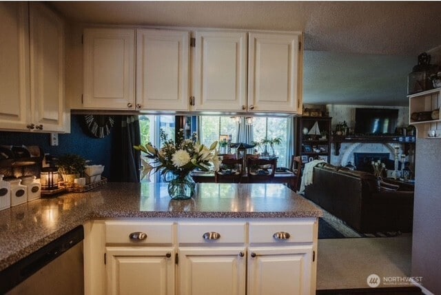 1327 Marie View St, Port Angeles, WA 98363 - kitchen featuring stainless steel dishwasher, white cabinetry, healthy amount of natural light, and dark stone countertops