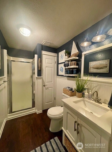 1327 Marie View St, Port Angeles, WA 98363 - bathroom featuring vanity, a stall shower, wood finished floors, a wainscoted wall, and a textured ceiling