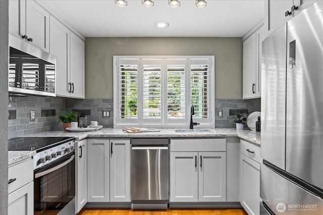 728 NW 189th Ln, Shoreline, WA 98177 - kitchen with stainless steel appliances, decorative backsplash, light stone counters, recessed lighting, and white cabinetry