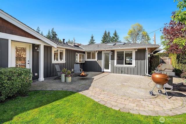 10261 NE 21st Pl, Bellevue, WA 98004 - rear view of house featuring board and batten siding, a patio, an outdoor fire pit, and a yard