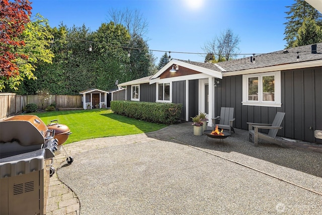 10261 NE 21st Pl, Bellevue, WA 98004 - fenced backyard featuring a patio area, a fire pit, and an outdoor structure