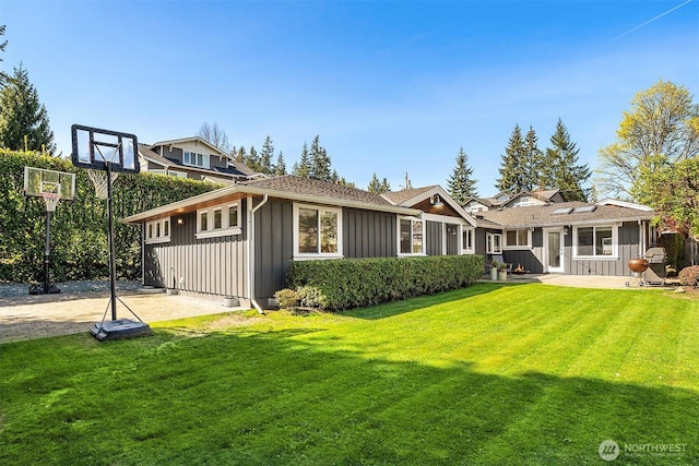 10261 NE 21st Pl, Bellevue, WA 98004 - rear view of house featuring board and batten siding, a yard, and a patio area