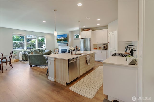 15539 Bergh Ct SE, Yelm, WA 98597 - kitchen featuring appliances with stainless steel finishes, open floor plan, a fireplace, recessed lighting, and light countertops