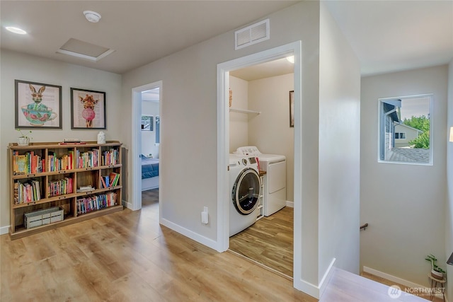 15539 Bergh Ct SE, Yelm, WA 98597 - laundry room featuring washing machine and clothes dryer, light wood-style flooring, and attic access