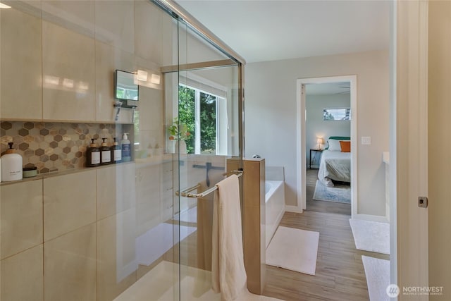 15539 Bergh Ct SE, Yelm, WA 98597 - ensuite bathroom featuring wood finished floors, a bath, a stall shower, and backsplash