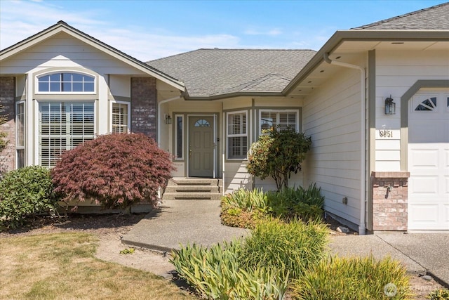 8051 283rd St NW, Stanwood, WA 98292 - view of exterior entry with an attached garage and a shingled roof