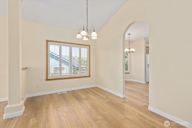 8051 283rd St NW, Stanwood, WA 98292 - unfurnished room featuring a chandelier, light wood finished floors, arched walkways, and vaulted ceiling