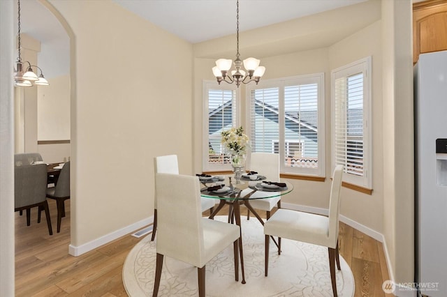 8051 283rd St NW, Stanwood, WA 98292 - dining area with a chandelier, light wood-style floors, and arched walkways