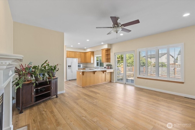 8051 283rd St NW, Stanwood, WA 98292 - kitchen with open shelves, white appliances, a kitchen bar, a fireplace, and ceiling fan