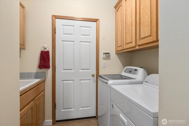8051 283rd St NW, Stanwood, WA 98292 - laundry room featuring washing machine and dryer, cabinet space, and wood finished floors