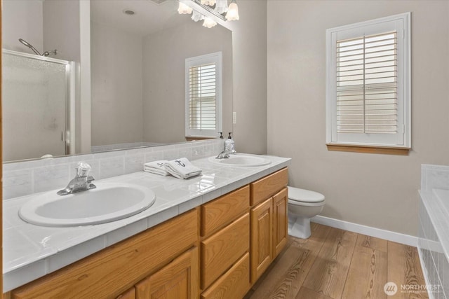 8051 283rd St NW, Stanwood, WA 98292 - bathroom with wood finished floors, double vanity, a shower stall, and a bath