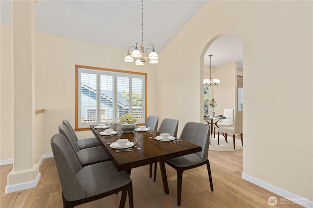 8051 283rd St NW, Stanwood, WA 98292 - dining space featuring a chandelier, light wood finished floors, arched walkways, and lofted ceiling