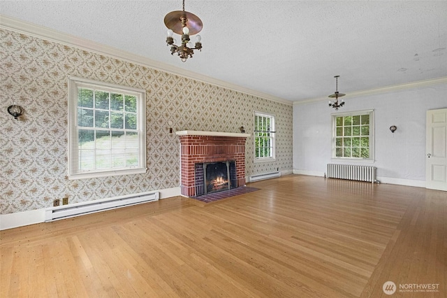 46372 E Main St, Concrete, WA 98237 - unfurnished living room with a baseboard heating unit, radiator, hardwood / wood-style floors, ornamental molding, and a chandelier