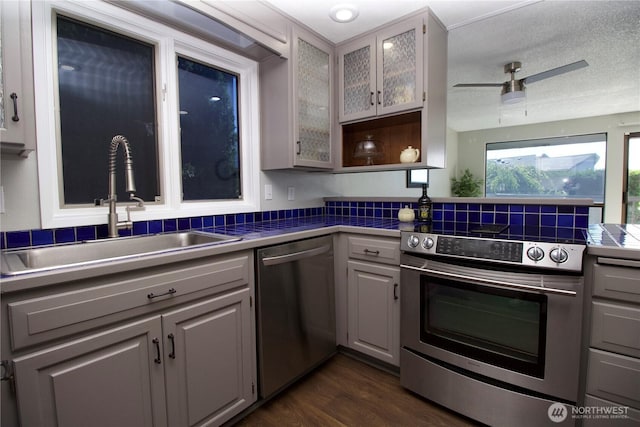 28635 11th Ave S, Federal Way, WA 98003 - kitchen with appliances with stainless steel finishes, tile counters, gray cabinetry, dark wood finished floors, and glass insert cabinets