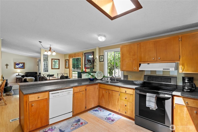 472 Iris Ln, Camano Island, WA 98282 - kitchen with white dishwasher, electric stove, under cabinet range hood, a peninsula, and a chandelier