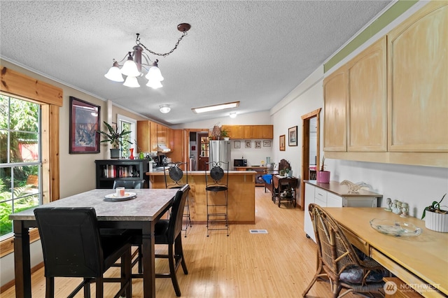 472 Iris Ln, Camano Island, WA 98282 - dining area with a chandelier, a textured ceiling, light wood-style flooring, and ornamental molding