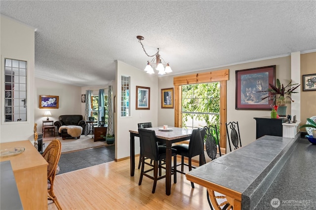 472 Iris Ln, Camano Island, WA 98282 - dining room with a textured ceiling, a chandelier, light wood finished floors, and crown molding
