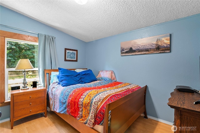 472 Iris Ln, Camano Island, WA 98282 - bedroom featuring wood finished floors, a textured ceiling, and lofted ceiling