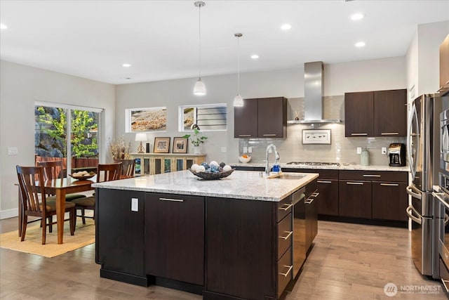 6010 155th St SW, Edmonds, WA 98026 - kitchen with wall chimney exhaust hood, light wood-style floors, an island with sink, tasteful backsplash, and recessed lighting
