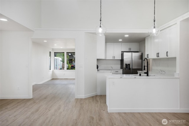 1308 133rd St S, Tacoma, WA 98444 - kitchen featuring stainless steel refrigerator with ice dispenser, white cabinetry, a peninsula, light wood finished floors, and recessed lighting