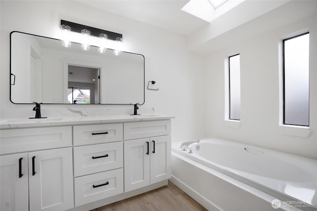 1308 133rd St S, Tacoma, WA 98444 - full bath with a skylight, double vanity, a bath, and wood finished floors