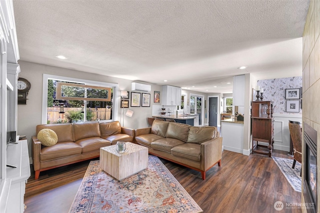 6008 S Bakerview Park Dr, Ferndale, WA 98248 - living area featuring an AC wall unit, a textured ceiling, a fireplace, dark wood finished floors, and plenty of natural light