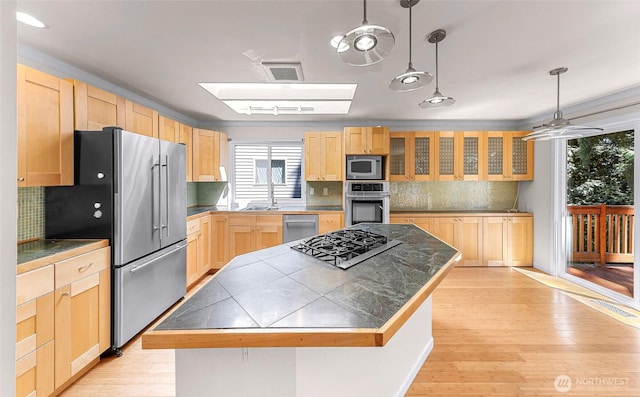 21313 2nd Dr SE, Bothell, WA 98021 - kitchen with appliances with stainless steel finishes, light brown cabinetry, tasteful backsplash, a center island, and light wood-style flooring