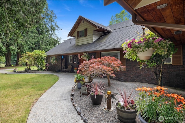 23019 Arlington Heights Rd, Arlington, WA 98223 - view of front facade with a front lawn, roof with shingles, brick siding, and a patio