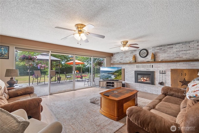 23019 Arlington Heights Rd, Arlington, WA 98223 - living room with a ceiling fan, a textured ceiling, a fireplace, and wood finished floors