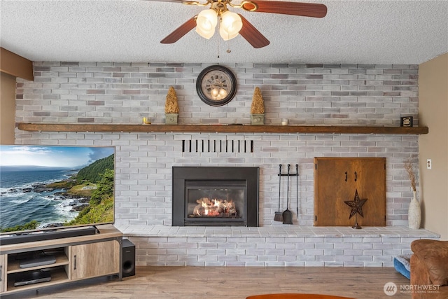 23019 Arlington Heights Rd, Arlington, WA 98223 - detailed view of a brick fireplace, a textured ceiling, wood finished floors, and a ceiling fan