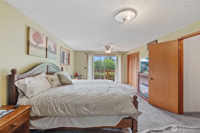 23019 Arlington Heights Rd, Arlington, WA 98223 - bedroom featuring access to outside, a textured ceiling, carpet, and a glass covered fireplace