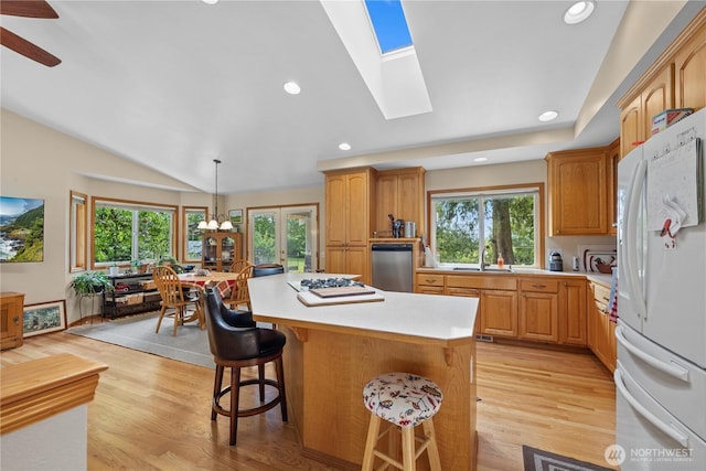 23019 Arlington Heights Rd, Arlington, WA 98223 - kitchen featuring freestanding refrigerator, a kitchen breakfast bar, light countertops, light wood finished floors, and vaulted ceiling