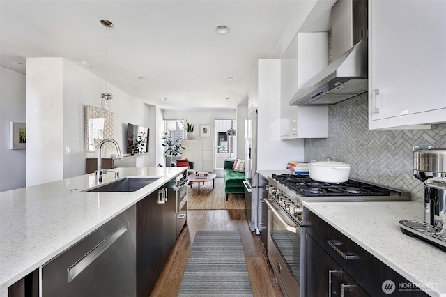 1117 34th Ave Unit B, Seattle, WA 98122 - kitchen with wall chimney range hood, high quality appliances, dark wood-type flooring, white cabinetry, and tasteful backsplash