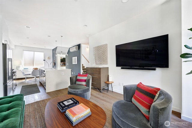 1117 34th Ave Unit B, Seattle, WA 98122 - living room with wood finished floors, stairs, a wall mounted AC, and recessed lighting