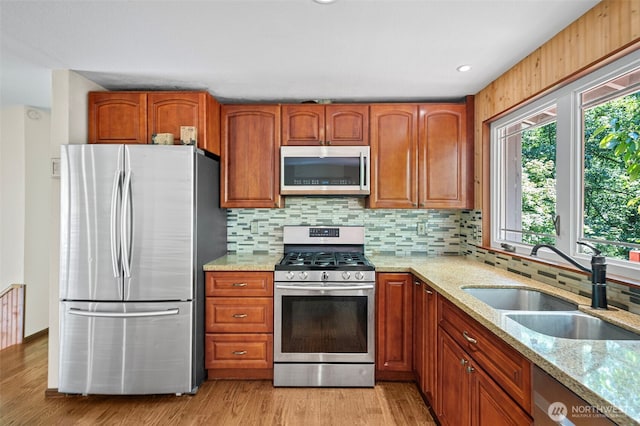 10122 50th Pl W, Mukilteo, WA 98275 - kitchen featuring stainless steel appliances, light stone counters, decorative backsplash, and light wood-style floors