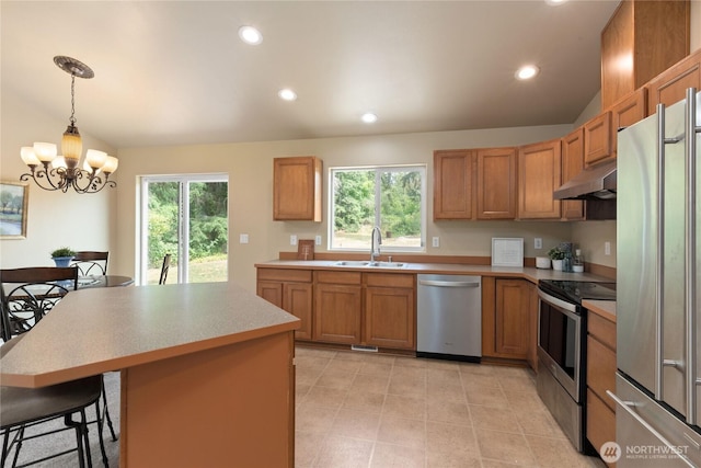 6401 151st St NW, Gig Harbor, WA 98332 - kitchen featuring appliances with stainless steel finishes, under cabinet range hood, a chandelier, light countertops, and healthy amount of natural light