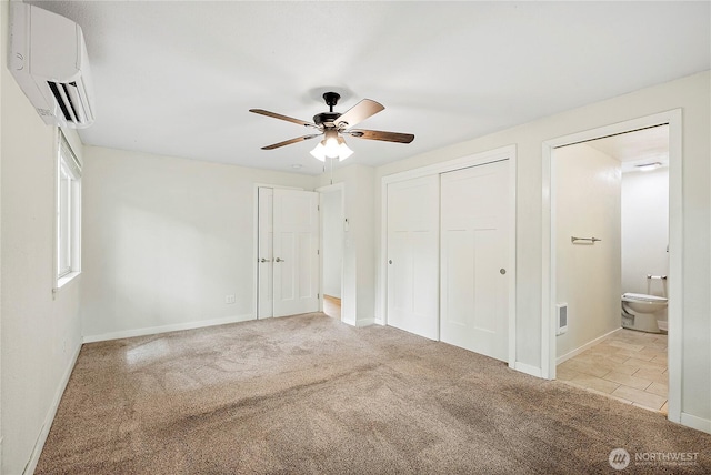 828 Gregory Way SE, Olympia, WA 98513 - unfurnished bedroom with a wall unit AC, carpet floors, ensuite bathroom, a closet, and a ceiling fan