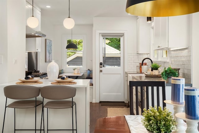 6518 18th Ave NE, Seattle, WA 98115 - kitchen with white cabinetry, a kitchen breakfast bar, tasteful backsplash, light countertops, and decorative light fixtures