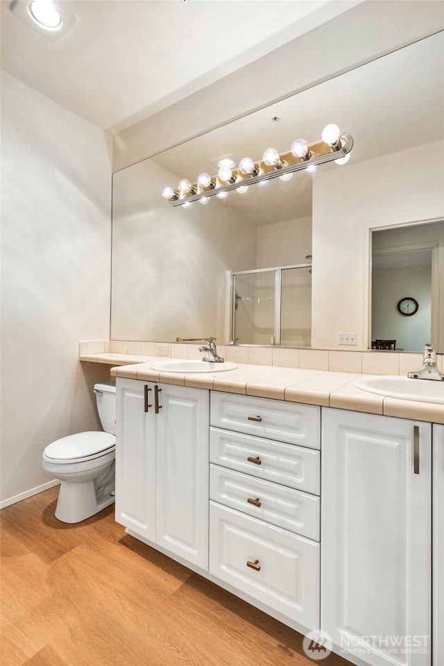 12712 Admiralty Way Unit B202, Everett, WA 98204 - bathroom featuring wood finished floors, double vanity, and a shower stall