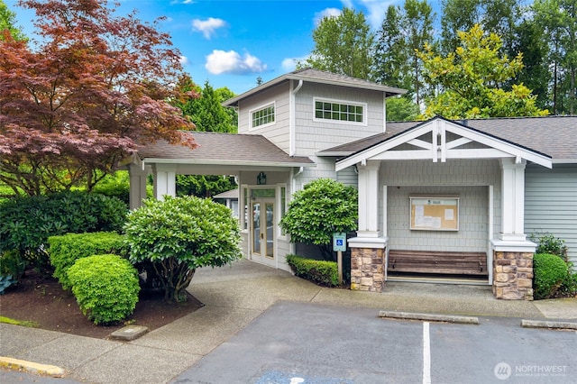 12712 Admiralty Way Unit B202, Everett, WA 98204 - view of front of home featuring a shingled roof, stone siding, and uncovered parking
