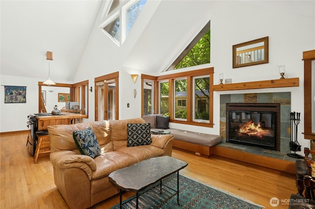 5579 NE Foster Rd, Bainbridge Island, WA 98110 - living area with high vaulted ceiling, healthy amount of natural light, wood finished floors, and a tile fireplace