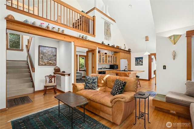 5579 NE Foster Rd, Bainbridge Island, WA 98110 - living area featuring high vaulted ceiling, light wood-style floors, and stairs