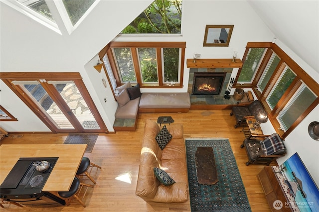 5579 NE Foster Rd, Bainbridge Island, WA 98110 - living room with wood finished floors, a fireplace, and a high ceiling