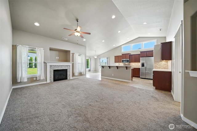 1330 Caprio Loop, Walla Walla, WA 99362 - unfurnished living room with light colored carpet, a ceiling fan, lofted ceiling, a tiled fireplace, and recessed lighting