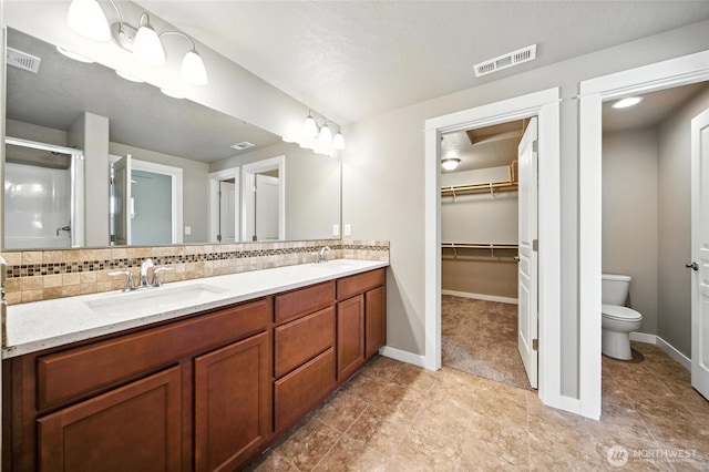 1330 Caprio Loop, Walla Walla, WA 99362 - full bath featuring double vanity, decorative backsplash, a stall shower, and a walk in closet
